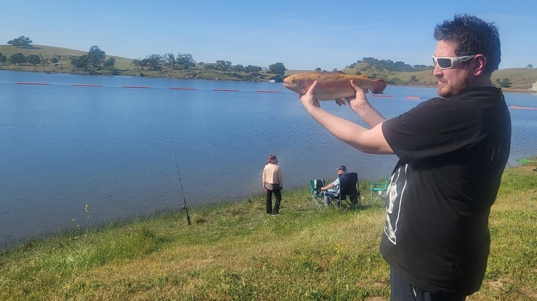 personne tenant de gros poissons sur le côté du lac McSwain près de Snelling, Californie
