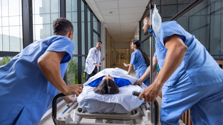 Les secouristes transportent d’urgence une femme sur une civière à l’hôpital