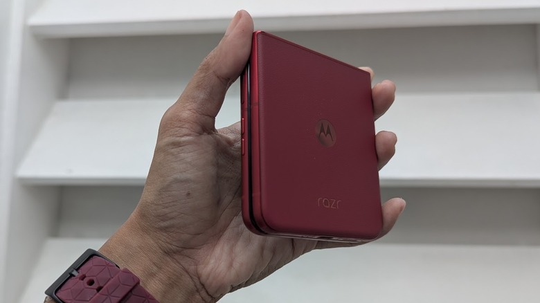 Main tenant un Motorola Razr Ultra 2025 plié contre un mur blanc
