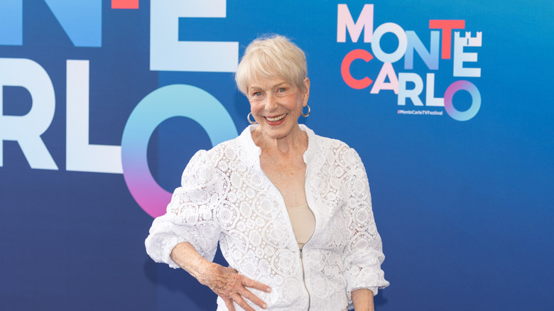 Karen Grassle sourit sur un tapis rouge en portant un haut blanc
