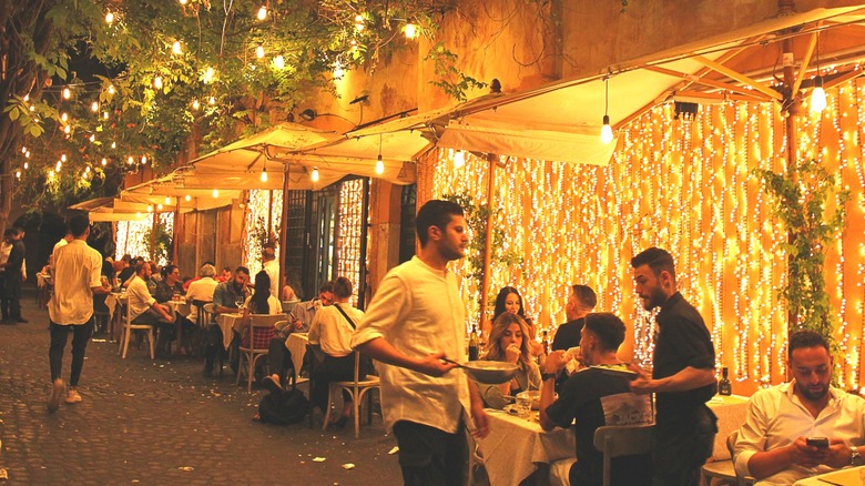 dîners aux tables extérieures du restaurant en Italie