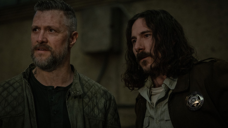 Shane McRae dans le rôle de Knox debout à côté de Billy Postlethwaite dans le rôle de l'adjoint Hank dans Silo