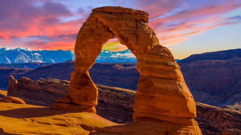 Arche délicate avec des montagnes enneigées en arrière-plan au parc national des Arches dans l'Utah