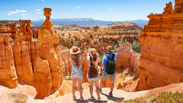 trois personnes regardant le marteau de Thor dans le parc national de Bryce Canyon