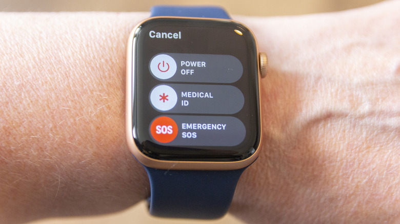 personne portant une Apple Watch Series 6 avec un bracelet bleu avec l'écran affichant le menu d'alimentation