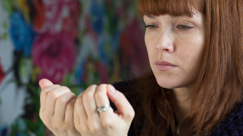 Femme inspectant ses ongles