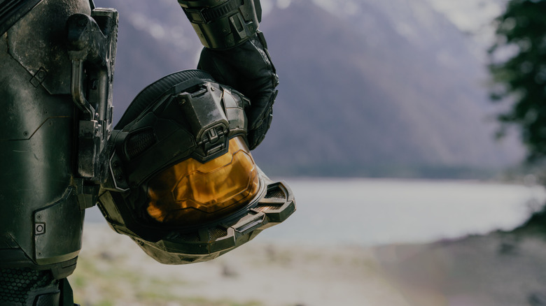 Un gros plan de Pablo Schreiber en tant que Master Chief tenant son casque à la main dans Halo