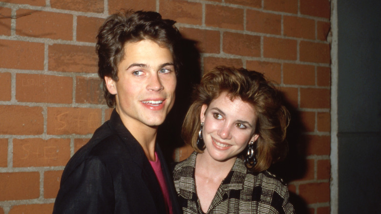 Les jeunes Rob Lowe et Melissa Gilbert devant un mur de briques