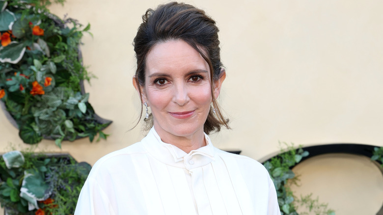 Tina Fey posant avec ses cheveux relevés et ses boucles d'oreilles pendantes