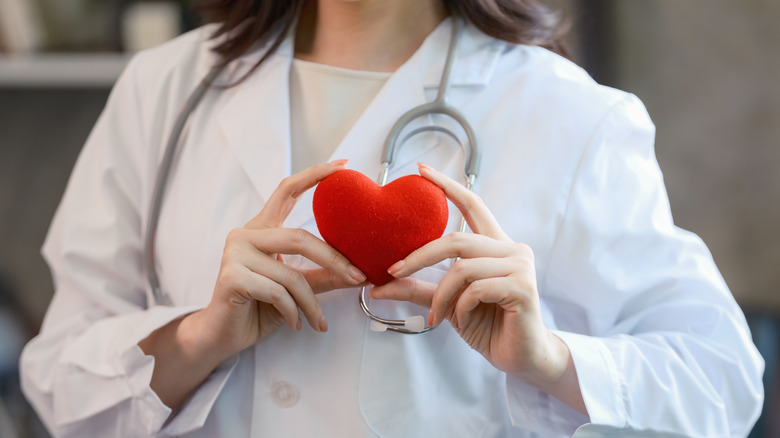 Docteur tenant un modèle de coeur