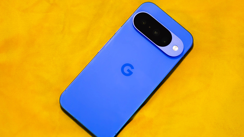 Google Pixel 10 bleu sur une surface jaune