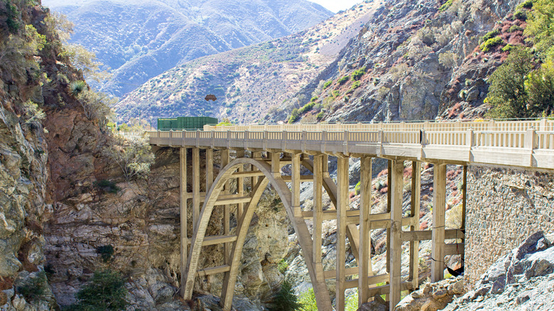 Pont en arc au-dessus du canyon avec toile de fond de montagne