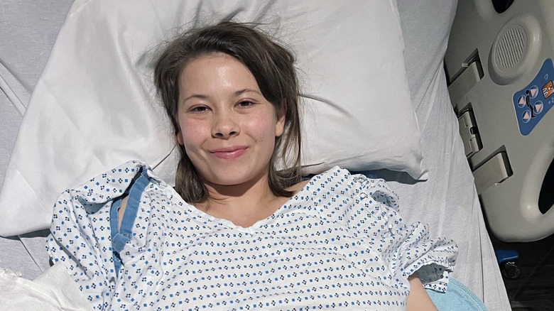Bindi Irwin dans un lit d'hôpital et une blouse après son opération de l'endométriose