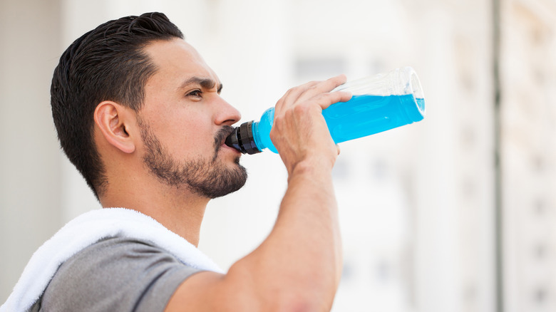 Homme buvant une boisson pour sportifs après avoir fait de l'exercice