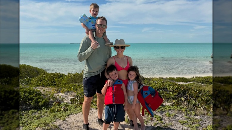 Shawn Johnson pose avec Andrew East et leurs trois enfants au bord d'une piscine