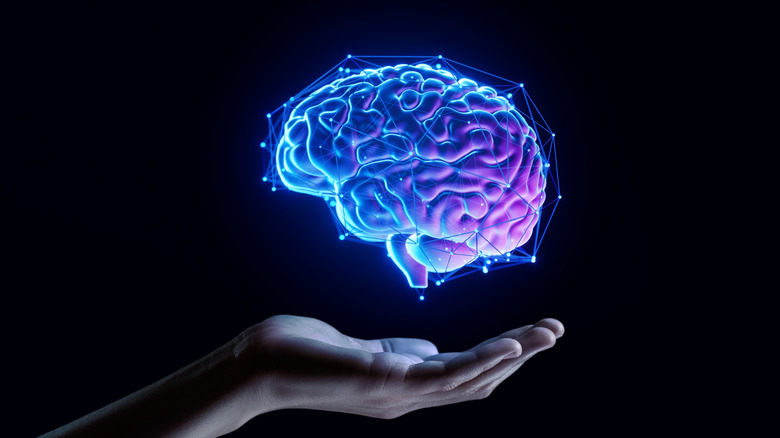 Une main tendue avec un graphique 3D représentant un cerveau flottant au-dessus