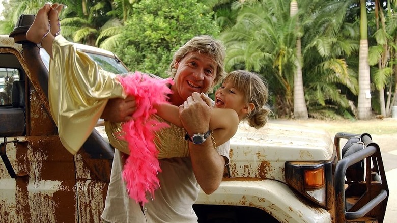 Steve Irwin tenant Bindi Irwin, habillée d'un boa en plumes roses