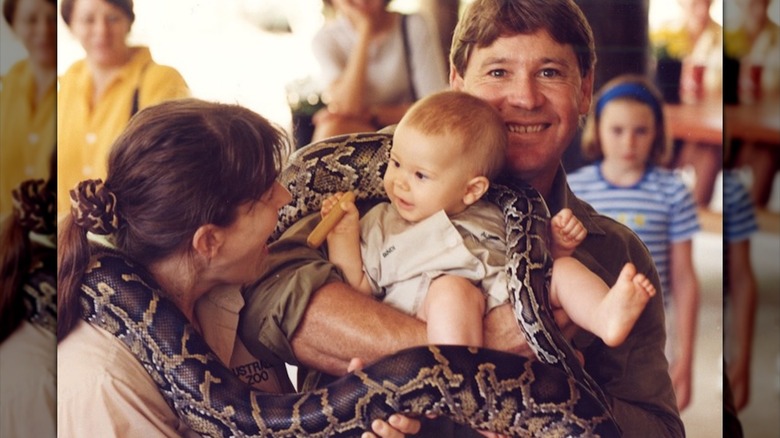 Steve Irwin et Bindi Irwin tiennent Bindi Irwin pendant qu'un python les entoure