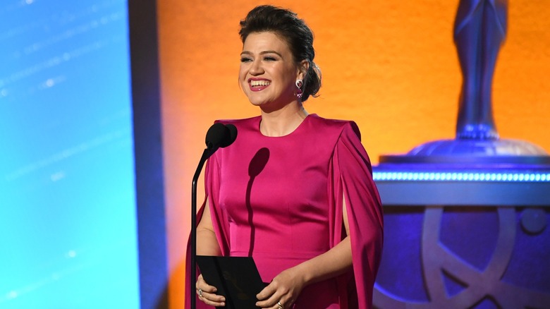 Kelly Clarkson remettant un prix aux Emmys 2024 vêtue d'une robe rose foncé.