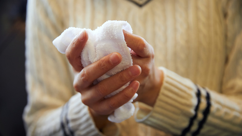 Gros plan sur les mains se lavant avec une serviette humide.