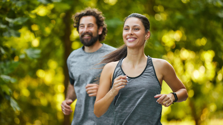 Jeune couple faisant du jogging dans les bois
