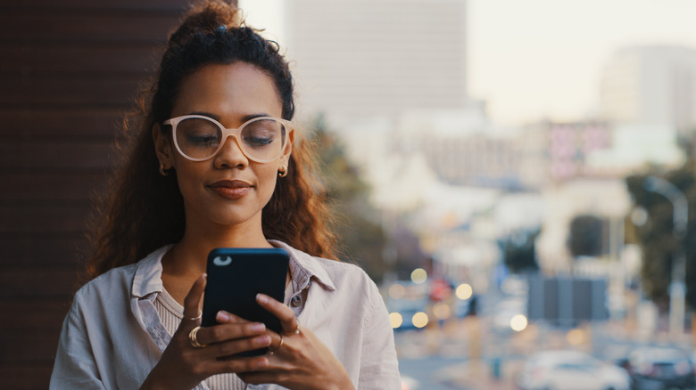 Une femme envoie des SMS sur son smartphone