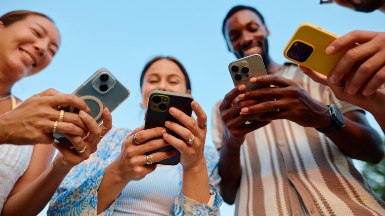 Quatre jeunes adultes utilisant des smartphones