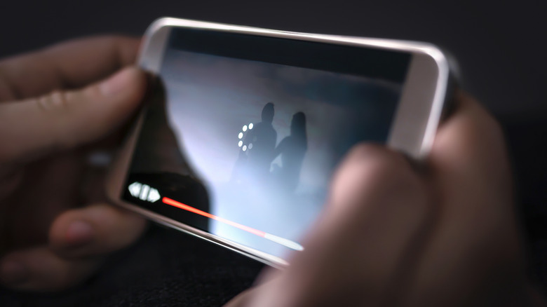 Un téléphone mettant en mémoire tampon et pendant la lecture vidéo, le ralentissant