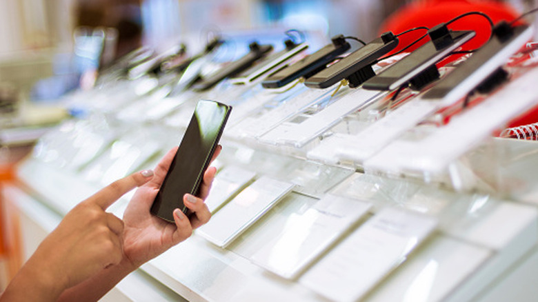 Une personne utilisant un téléphone dans un magasin.