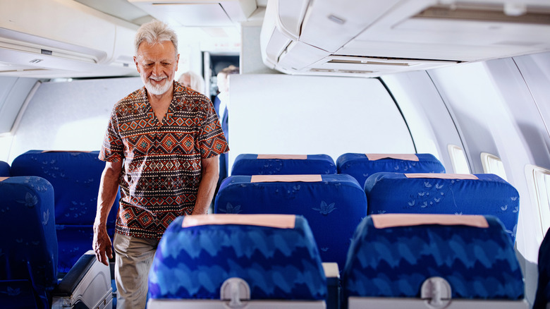 homme âgé marchant dans un avion