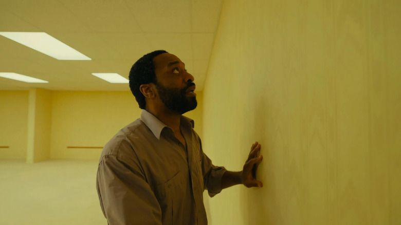 Clark regarde par-dessus le mur des backrooms dans Backrooms