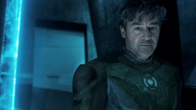 Hal Jordan de Kyle Chandler se tient dans une pièce sombre portant son costume Green Lantern dans Lanterns