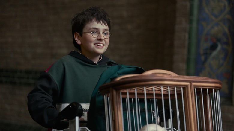 Harry poussant son chariot à travers King's Cross dans le