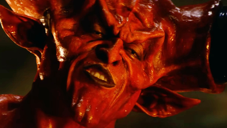 Tim Curry dans le rôle de Darkness souriant avec confiance dans Legend