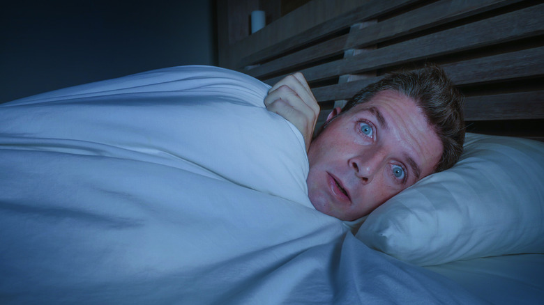 Un homme au lit qui a l'air horrifié
