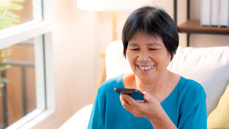 Femme parlant dans son téléphone, faisant une note vocale