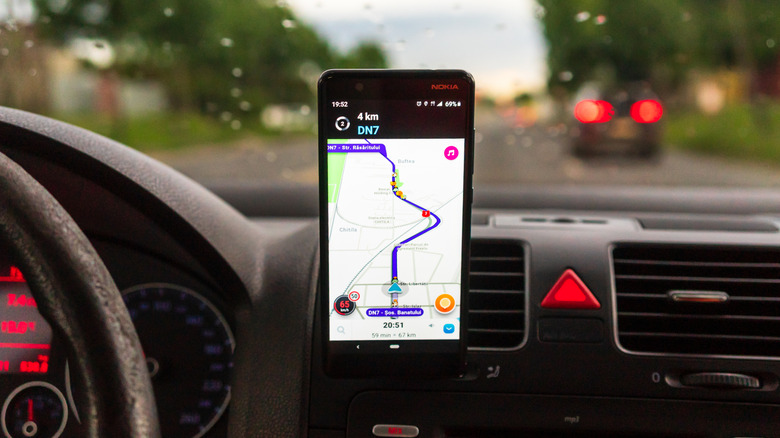 Application Waze affichant la navigation sur un téléphone Android monté sur le tableau de bord d'une voiture