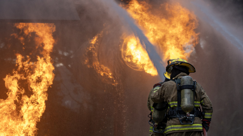 Un pompier éteint un incendie d'avion.