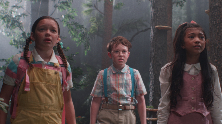 Freddy, Oliver et Hannah se tiennent dans les bois avec des regards terrifiés sur leurs visages dans Buddy