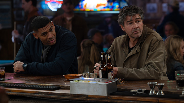 John Stewart d'Aaron Pierre est assis aux côtés de Hal Jordan de Kyle Chandler dans un bar de Lanterns