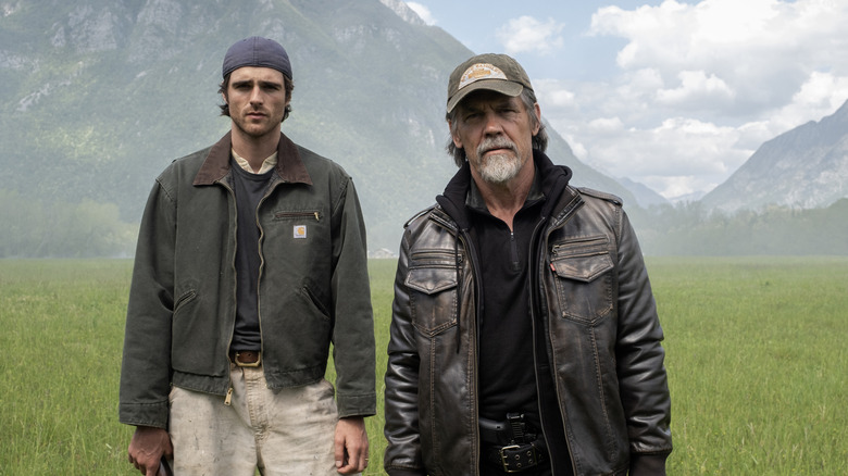 Jacob Elordi dans le rôle de Hig debout à côté de Josh Brolin dans le rôle de Bangley dans un champ dans The Dog Stars