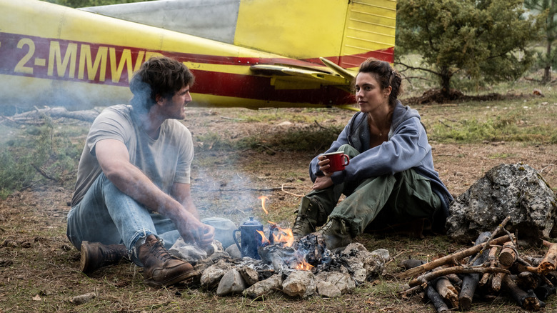 Jacob Elordi dans le rôle de Hig assis à côté de Margaret Qualley dans le rôle de Cima près d'un feu dans The Dog Stars