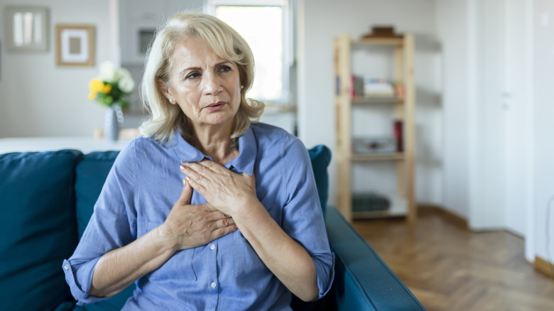 Femme tenant sa poitrine et semblant inquiète