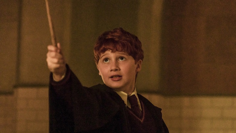 Ron tenant sa baguette en l'air dans Harry Potter et la pierre philosophale