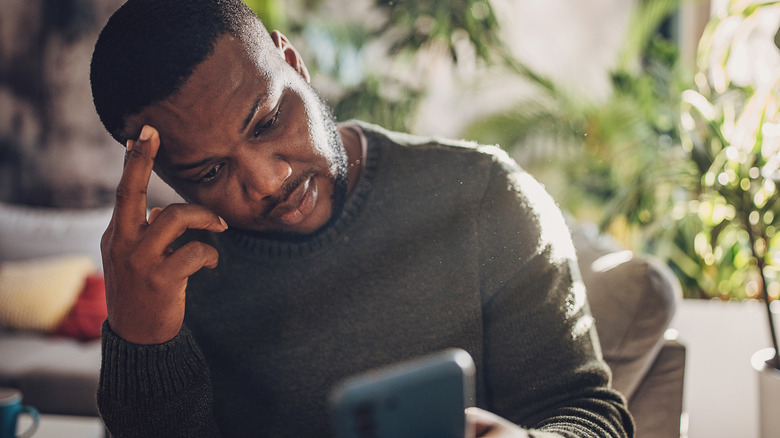 Personne regardant son téléphone, frustrée