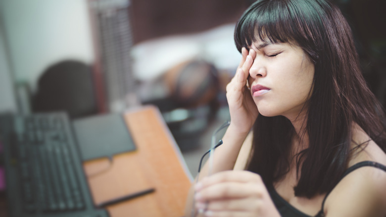 Femme touchant les yeux, ressentant la tension du travail en gros plan