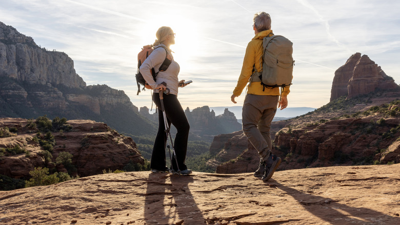 homme et femme debout sur un plateau de montagne regardant d'autres formations rocheuses