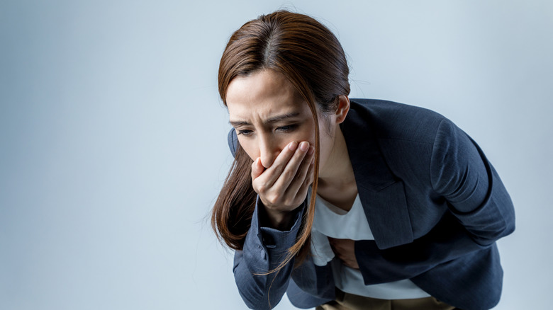 Jeune femme se sentant nauséeuse, tenant la bouche