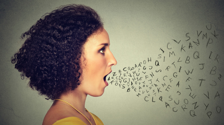 Profil de jeune femme avec la bouche ouverte et un flux de lettres griffonnées le laissant