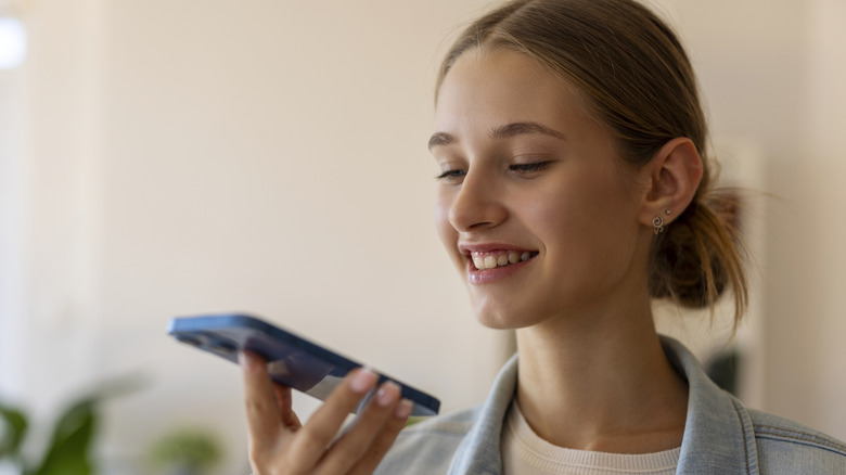 jeune femme parlant à Siri sur iphone